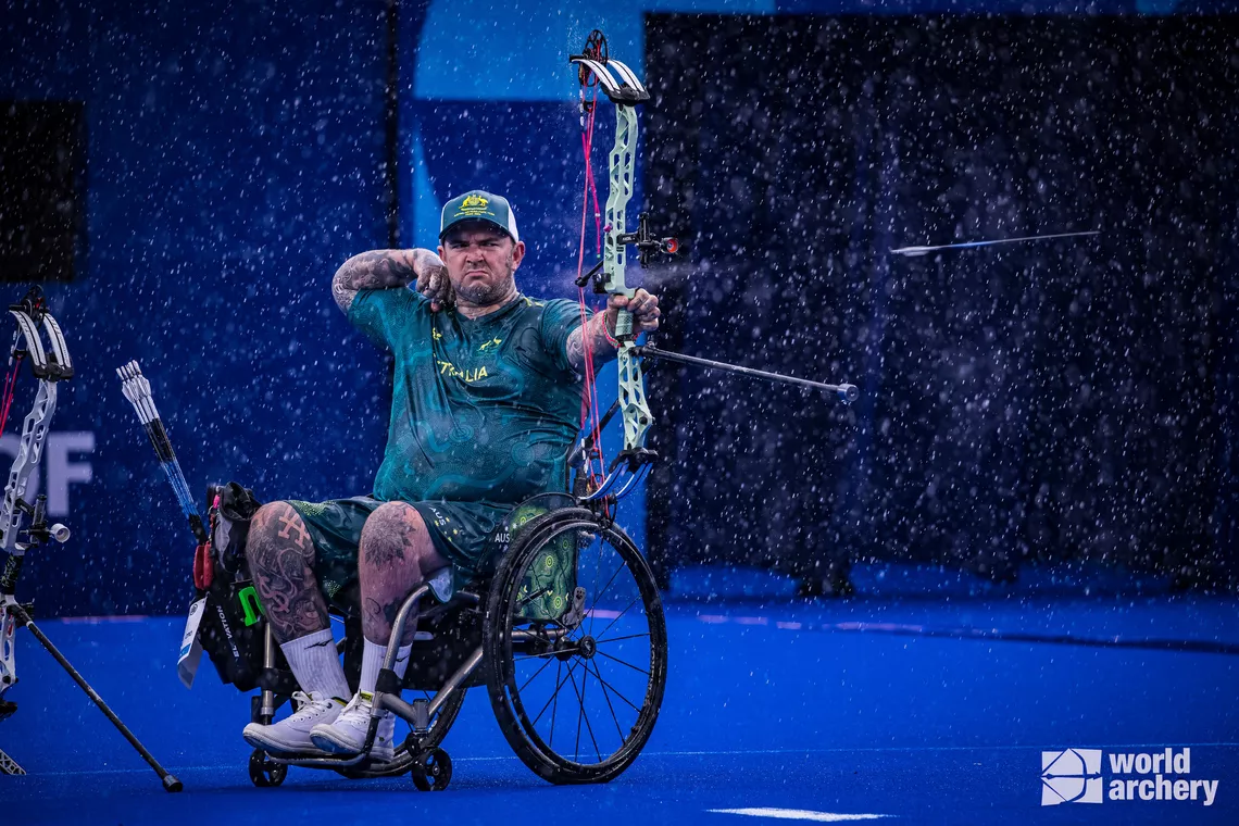 Patrick French shooting under heavy rain in Paris 2024 Paralympics.