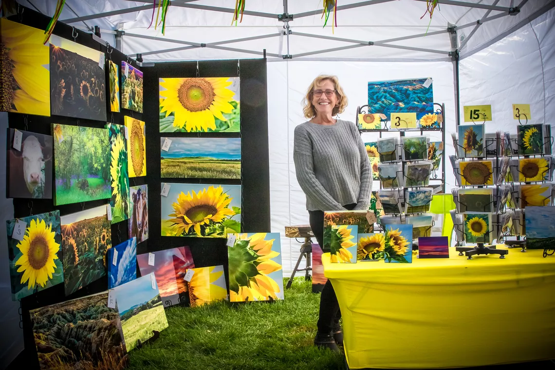 Sally Schroeder poses with her artwork at the Yankton 2021 Hyundai World Archery Championships. 