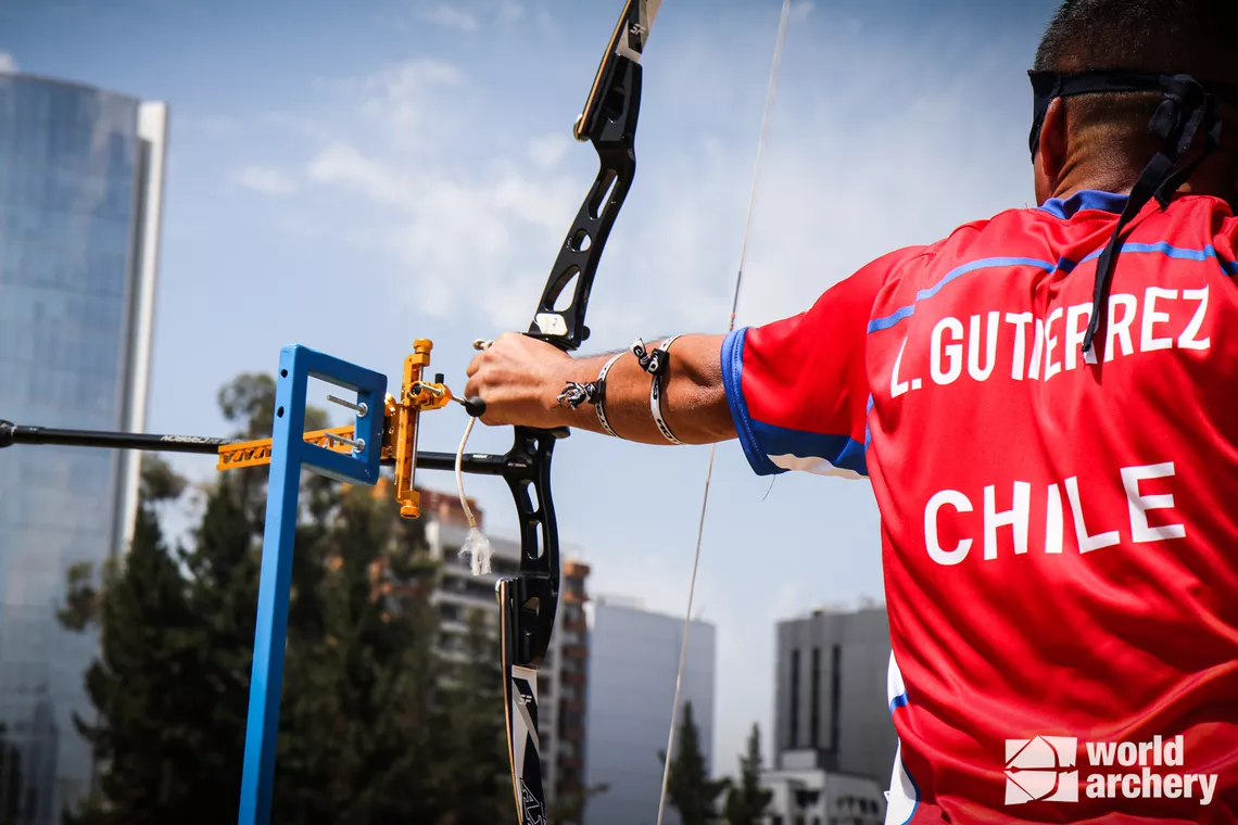 Visually impaired archers aim using a tactile sight, which touches the back of their hand.