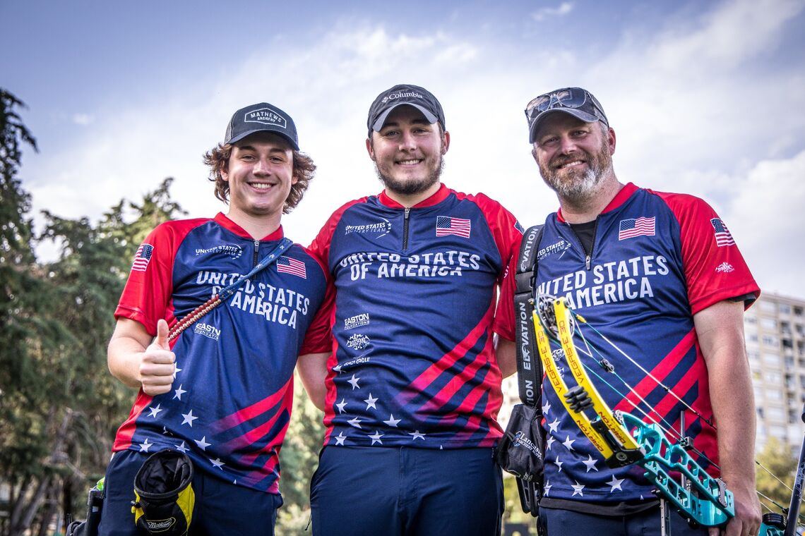 来自美国复合队的三名男子用鞠躬对着镜头微笑