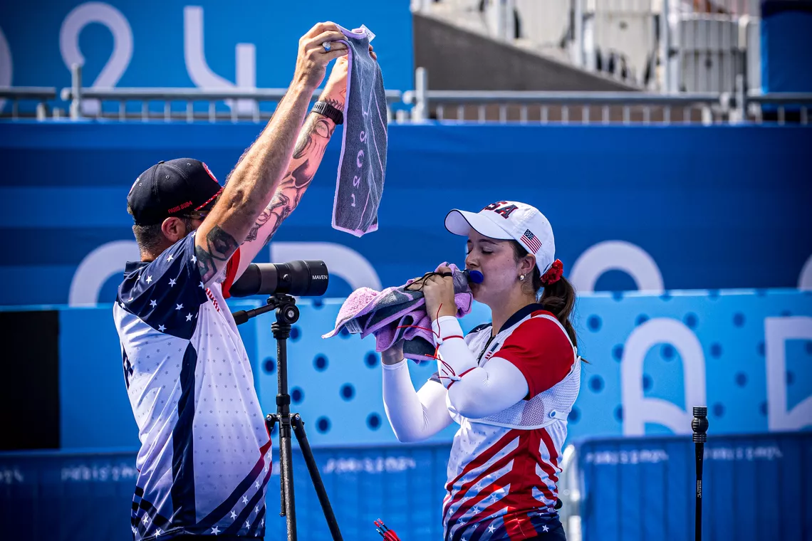 Catalina Gnoriega drinking water and getting crowded from the heat by her coach in Paris.