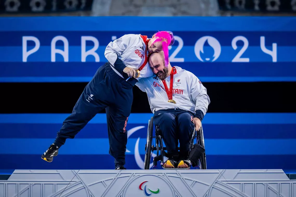 Jodie Grinham and Nathan MacQueen on top of Paris 2024 Paralympic podium.