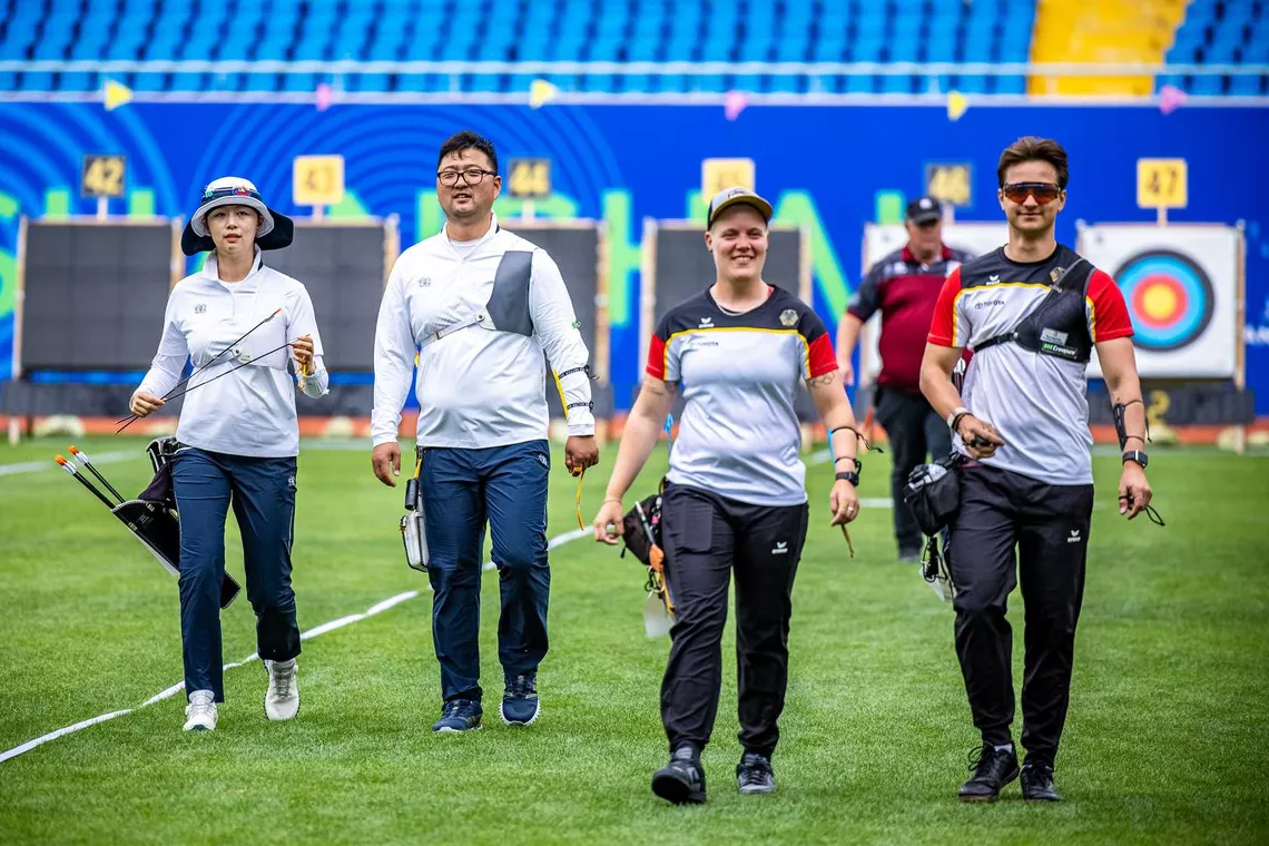 Lim Sihyeon, Kim Woojin, Michelle Kroppen and Moritz Wieser walking back from the target.