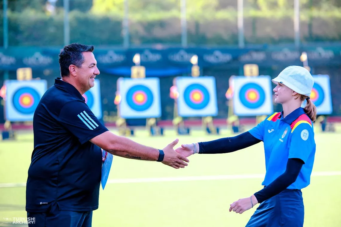 Ergin Goktug handing training camp participation certificate to young athlete.