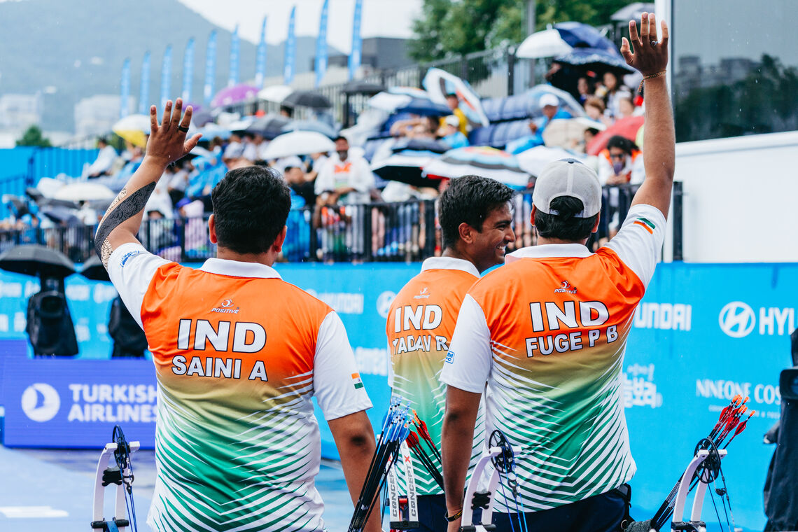 India compound men's team waving to the crowd.