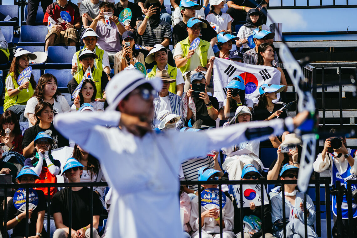 An San shooting with Korean fans in background. 
