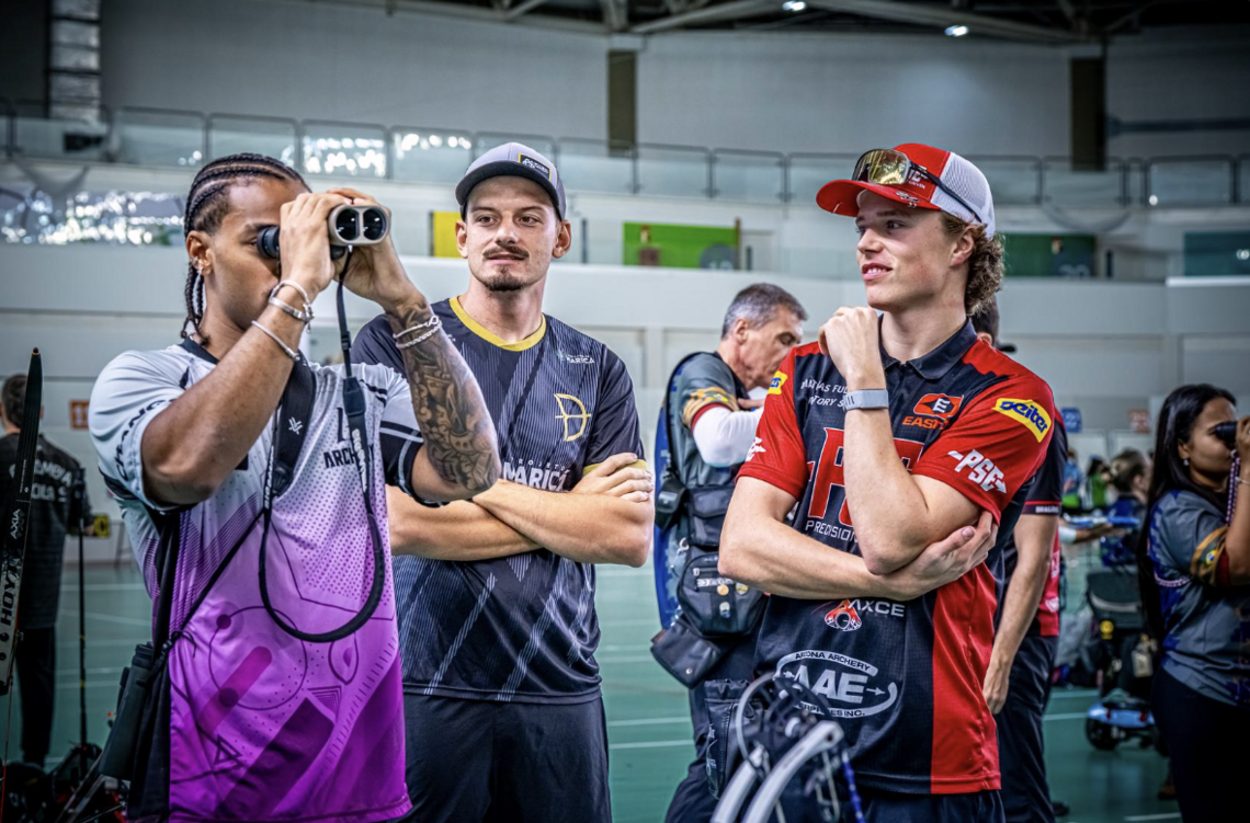 Mathias Fullerton and Marcus D'Almeida watching Luccas Abreu look through binoculars.