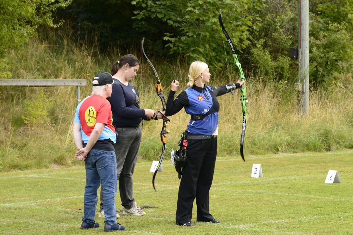 Jens Fudge coaching the two barebow girls from different clubs at National Youth Championships.