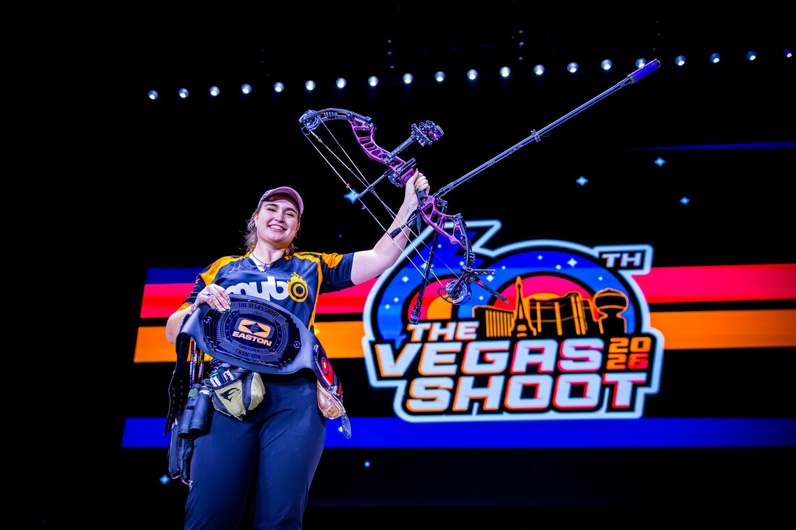 An archer poses with an award