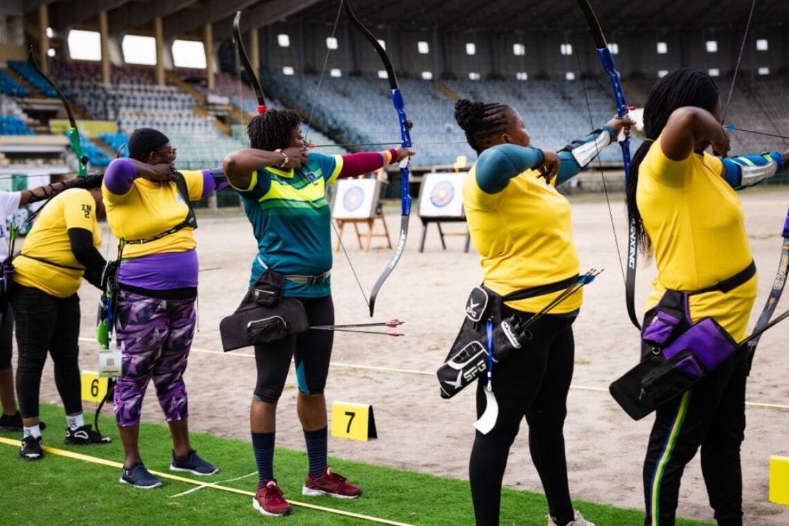 Nigerian barebow women archers shooting.