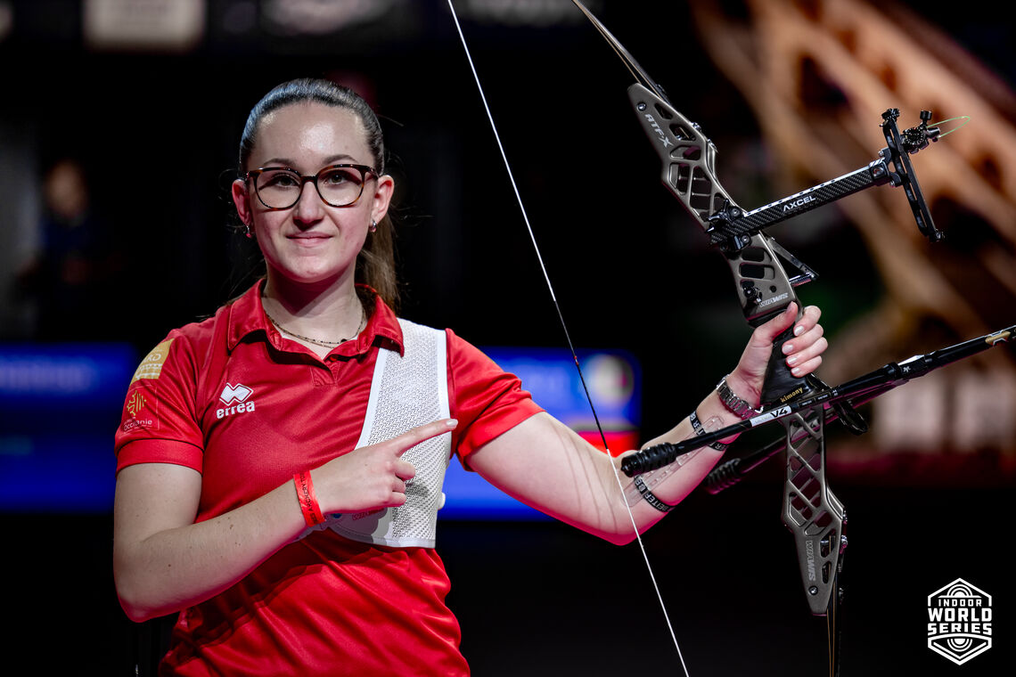An archer poses with her bow