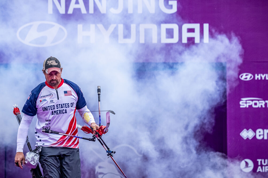 Brady Ellison walking out from the smoke at the Nanjing 2025 World Cup Final.