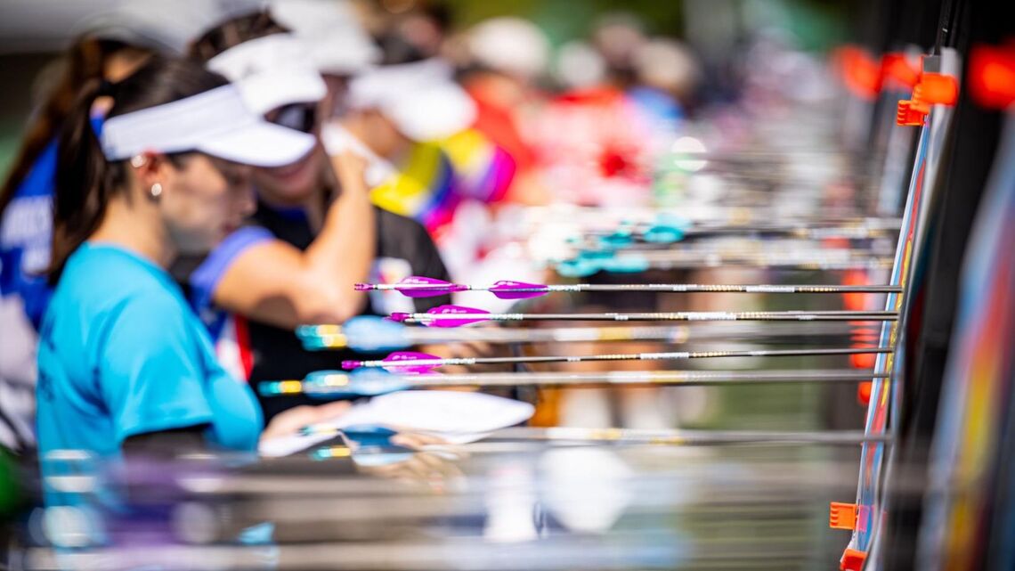 A group of archers looking at where their arrows landed on the targets.