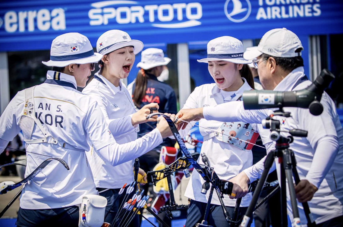 An San, Lim Sihyeon and Kang Chaeyoung fistbumping each other and their coach.
