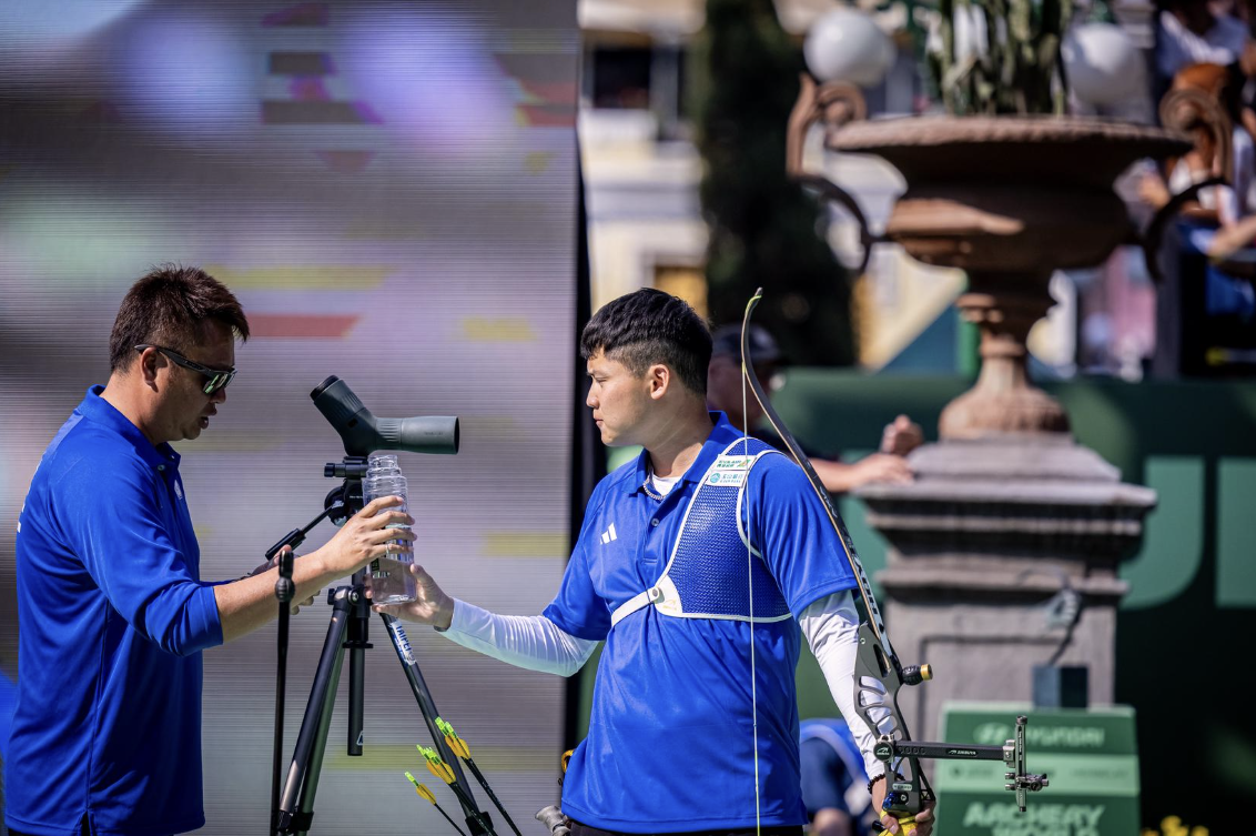 Tang Chih-Chun getting a water bottle from his coach during a match at Puebla 2026. 