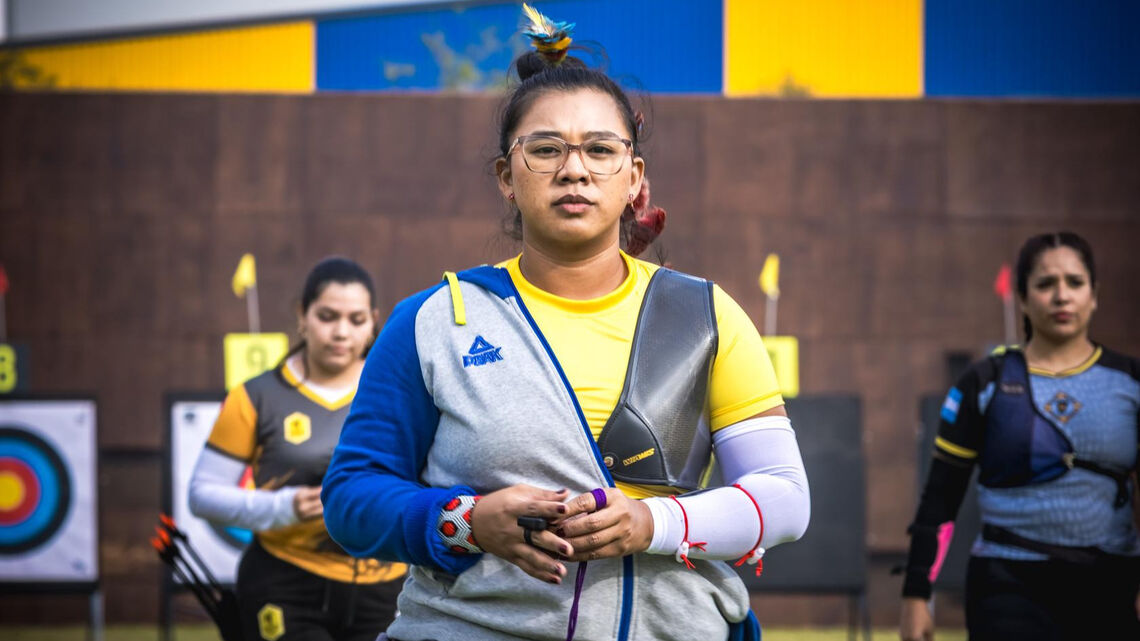 An archer poses after her round