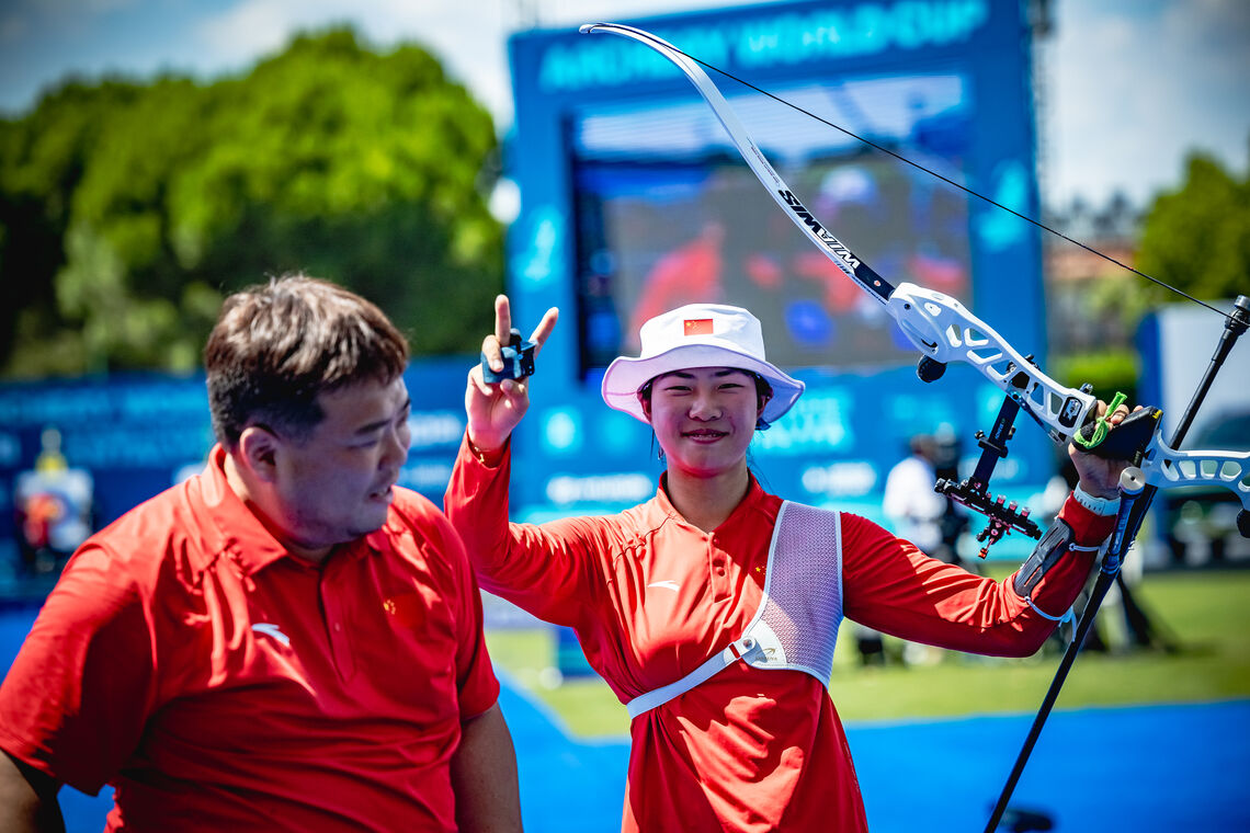 Zhu Jingyi doing the peace sign with coach Kwon Yonghak smiling next to her at Antalya 2026.
