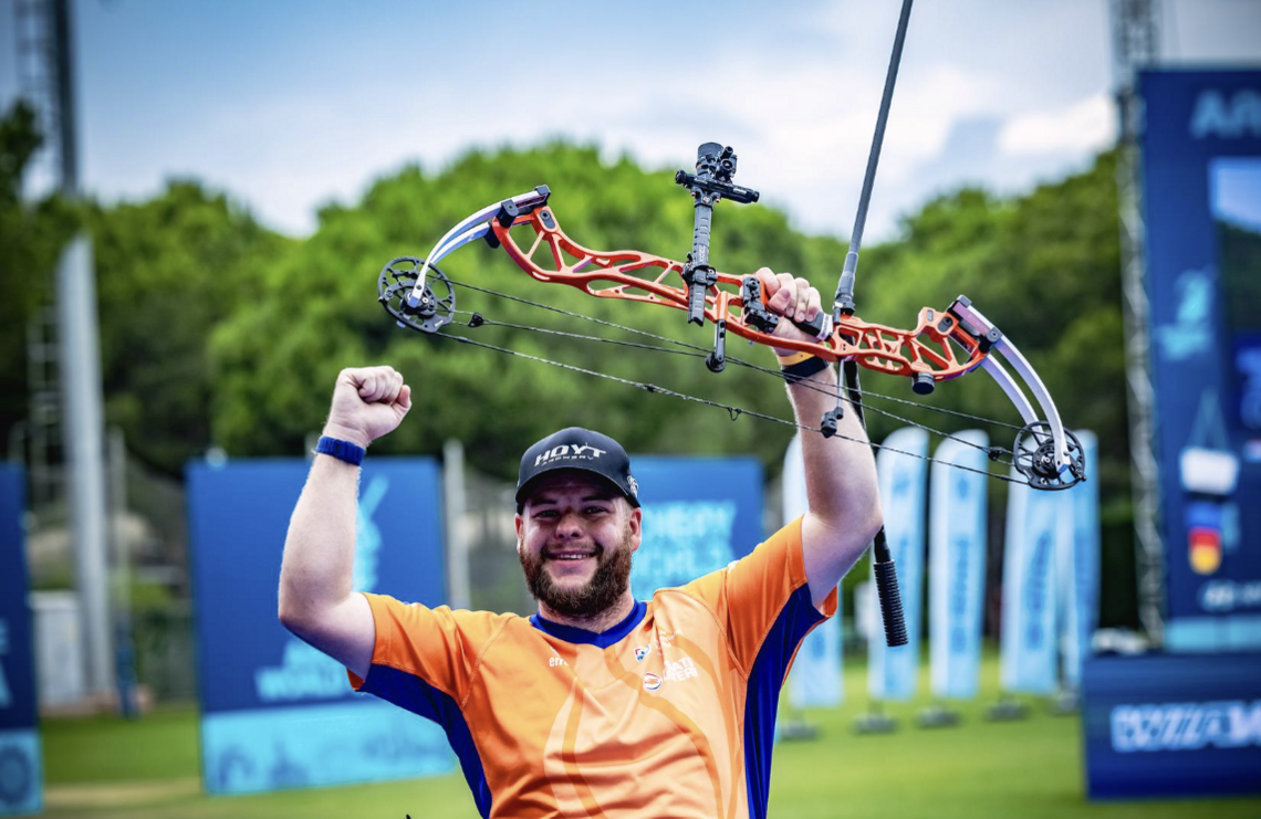 Mike Schloesser raising his fist and bow in the air after winning gold at Antalya 2026.