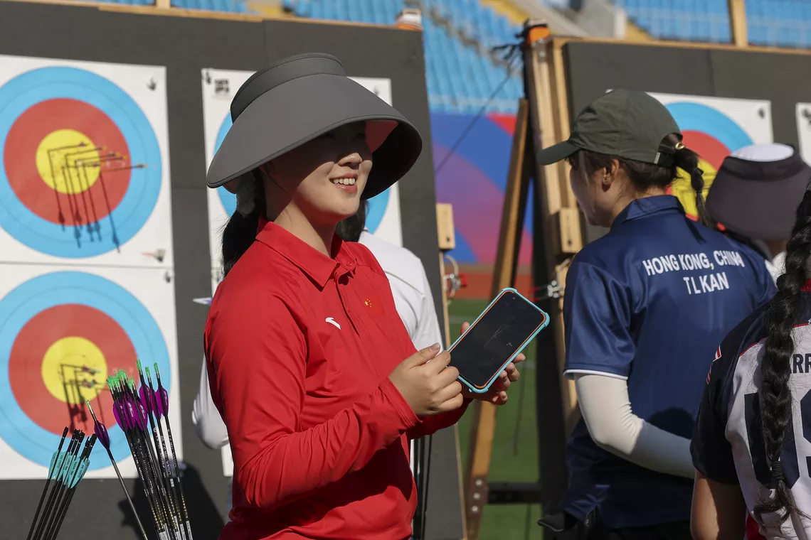 Ma Shujia smiling and checking scores at the target at Shanghai 2026.