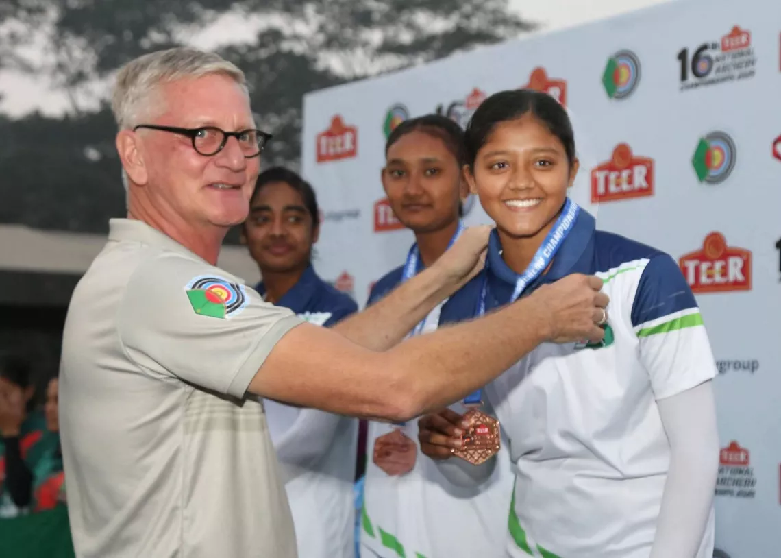 Saima Salah Uddin receives medal from Bangladesh head coach Martin Frederick.