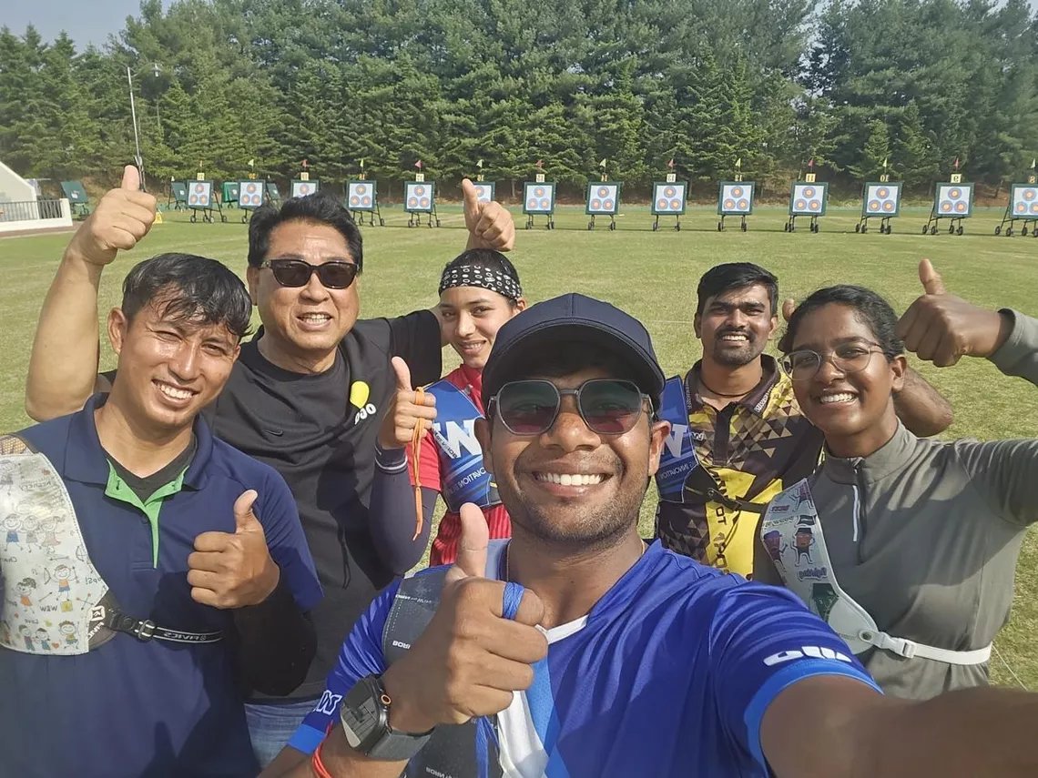Dhiraj Bommadevara posing with a thumb up at Olympic Gold Quest in Pune with Kim Hag Yong and other archers.