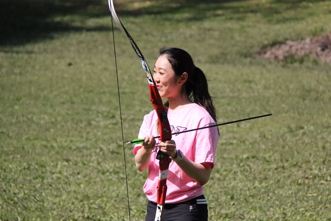 Katherine Wu holding a beginner bow during a session of Archery RX.