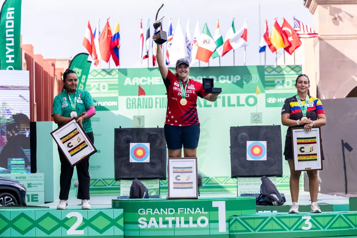 Alexis Ruiz raising the Archery World Cup trophy on the podium alongside Dafne Quintero and Sara Lopez at Saltillo 2026.