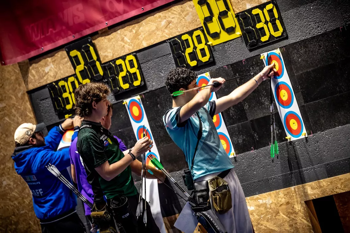 Recurve archers pulling arrows out of the target at the 2025 Swiss Open Lausanne.