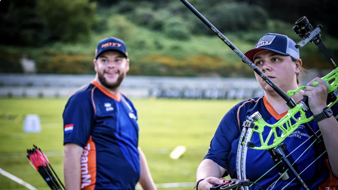 Sanne De Laat holding bow, Mike Schloesser smiling after winning shoot off against Mexico.