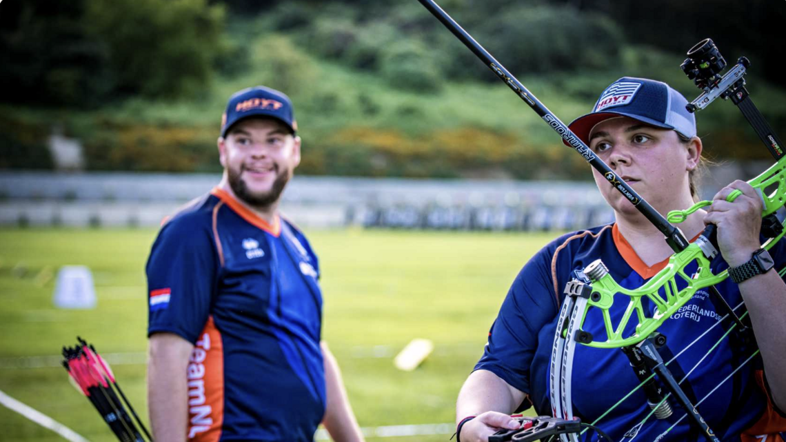 Sanne De Laat holding bow, Mike Schloesser smiling after winning shoot off against Mexico.