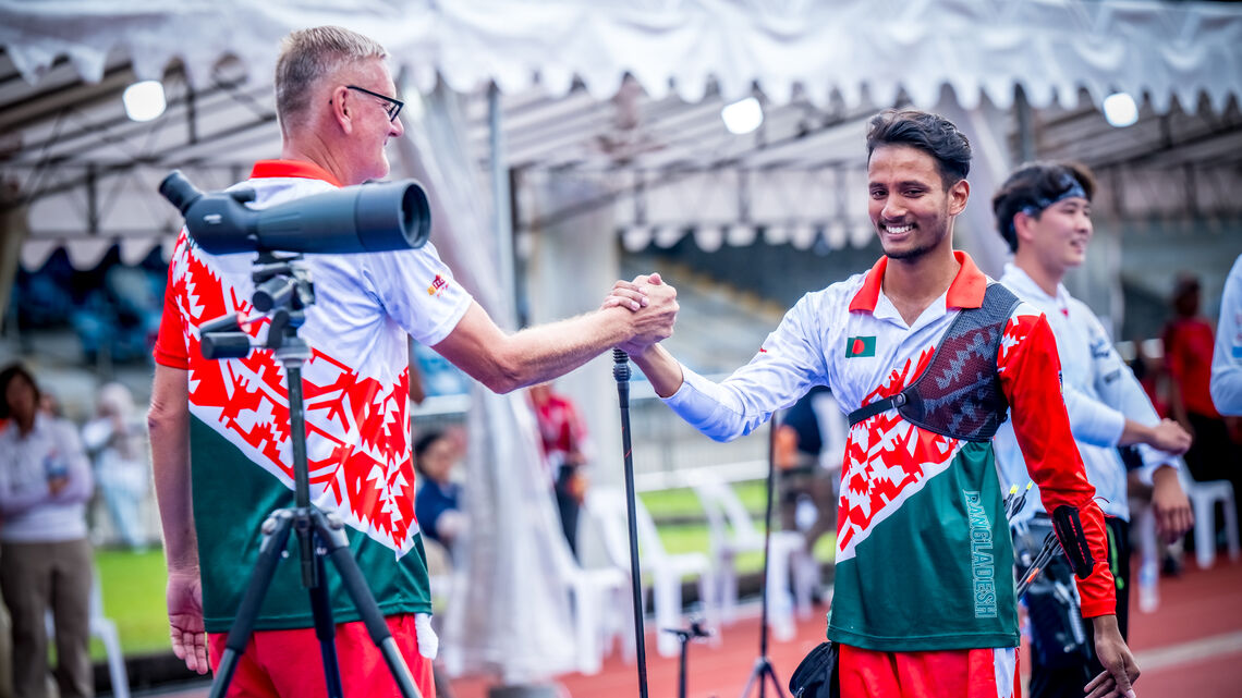 An athlete celebrates a good round with coach.