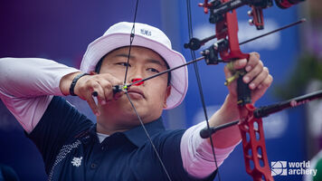 Kang Donghyeon shoots in the mixed team bronze medal match in Medellin in 2022.