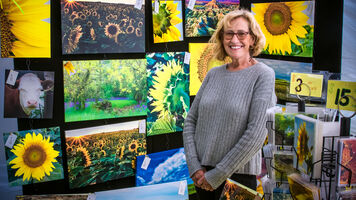 Sally Schroeder poses with her artwork at the Yankton 2021 Hyundai World Archery Championships. 