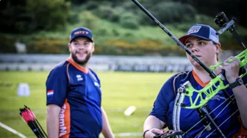 Sanne De Laat holding bow, Mike Schloesser smiling after winning shoot off against Mexico.