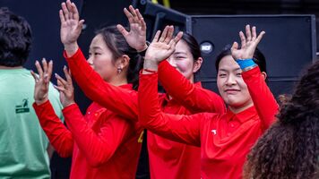 Yu Qi, Zhu Jingyi, and Huang Yuwei waving to the crowd on the podium at Puebla 2026.